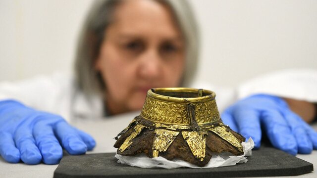 این تصویر بقایای ظرف چوبی را نشان می‌دهد که با استفاده از طلا تزئین شده است